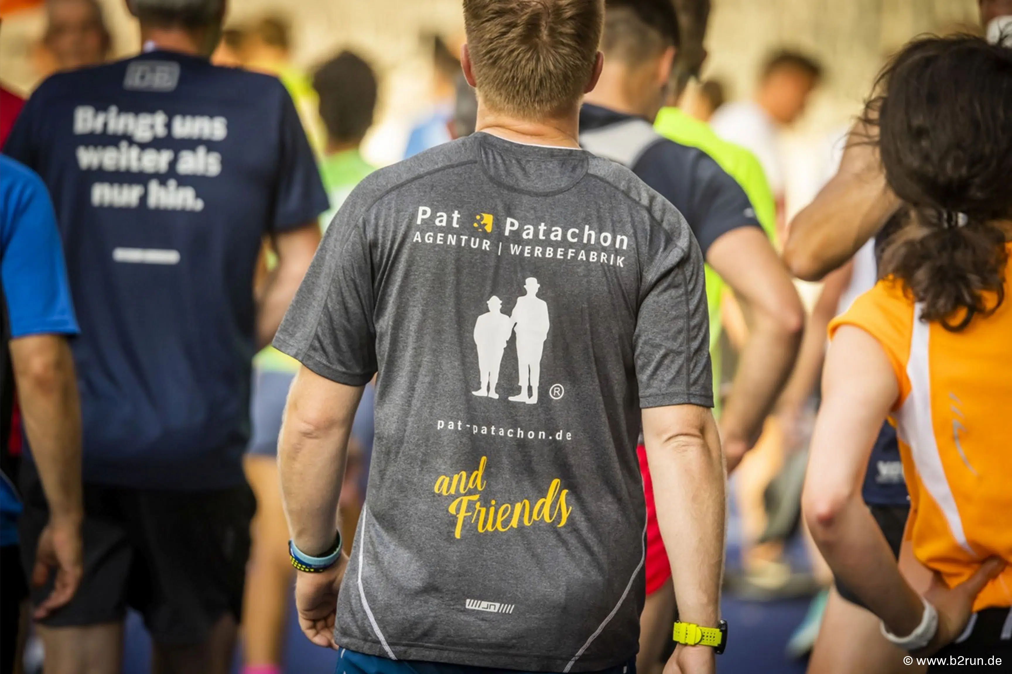 Ein Teilnehmer des B2Run mit dem Pat & Patachon Shirt „and Friends“ inmitten der Läufermenge. Das Team zeigt Zusammenhalt und Motivation beim Firmenlauf-Event, das sportlichen Ehrgeiz und Teamgeist verbindet.