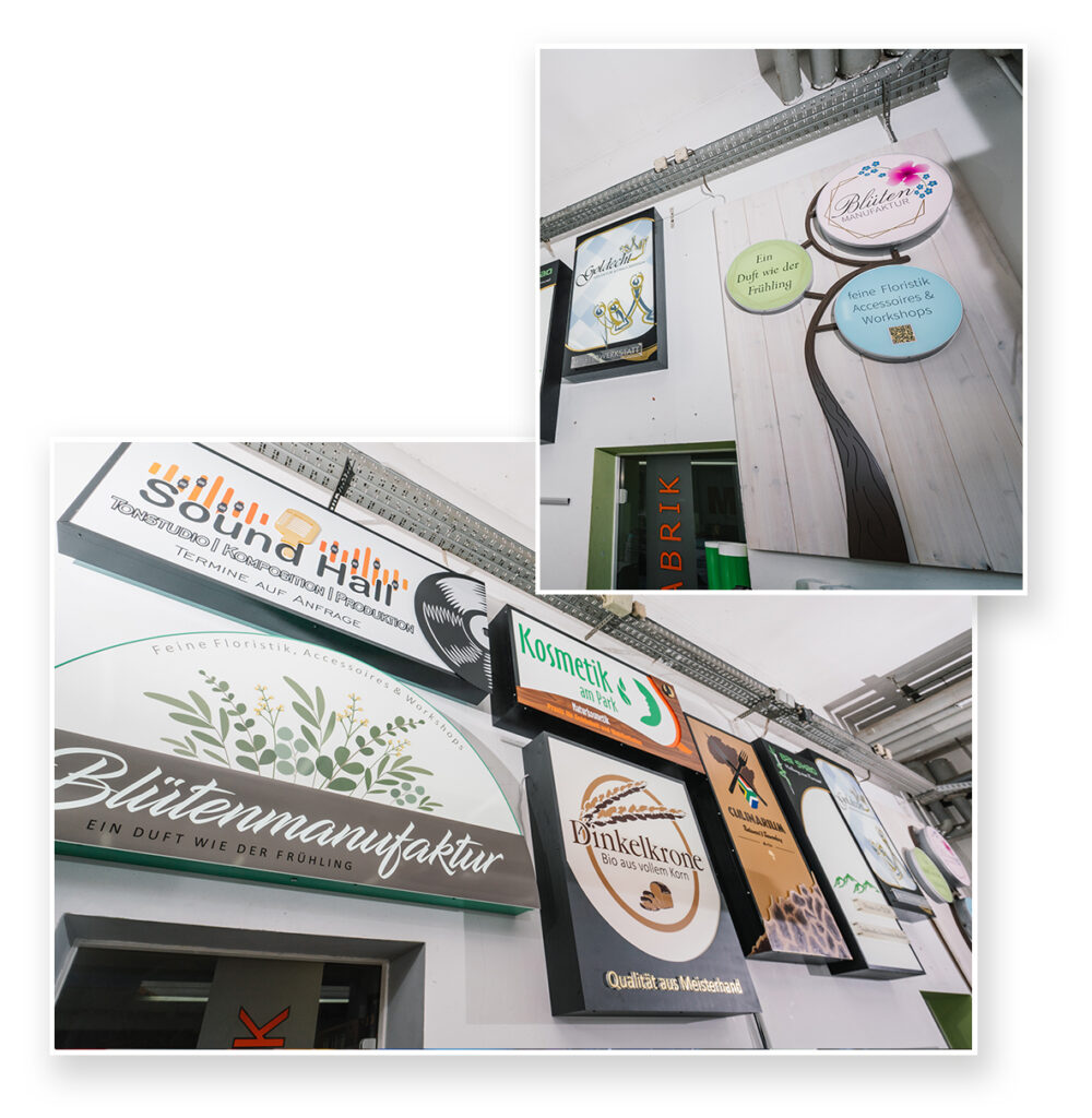 Das Bild zeigt verschiedene Werbeschilder an einer Wand, darunter beleuchtete und unbeleuchtete Schilder mit unterschiedlichen Designs und Logos. Die Schilder gehören zu Unternehmen aus verschiedenen Branchen, wie Floristik, Kosmetik und Bäckereien.