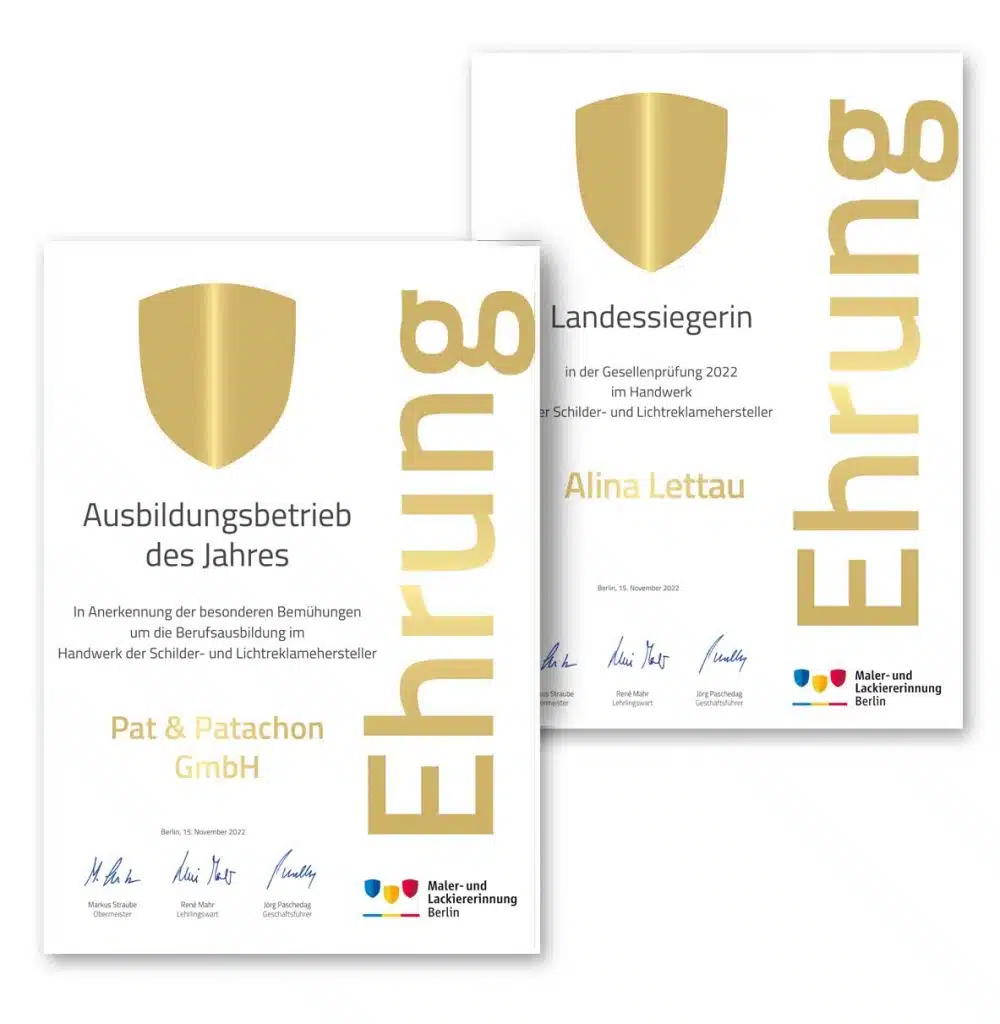 Zwei Urkunden mit goldener Beschriftung 'Ehrung' und Wappen-Symbol. Die vordere Urkunde zeichnet Pat & Patachon GmbH als 'Ausbildungsbetrieb des Jahres' aus, die hintere ehrt Alina Lettau als 'Landessiegerin' in der Gesellenprüfung 2022. Logos der Maler- und Lackierinnung Berlin unten.