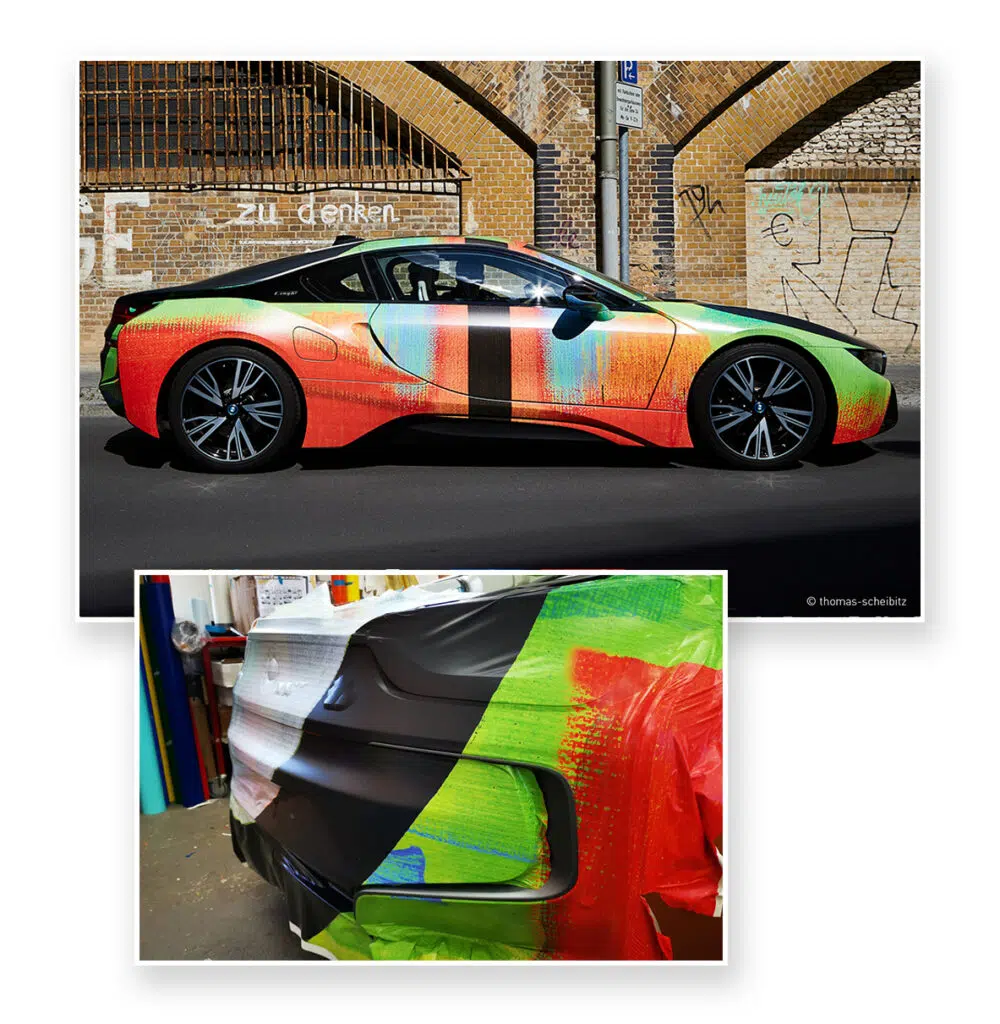 Ein BMW i8 mit bunter, künstlerischer Vollfolierung in Rot, Grün und Blau, geparkt vor einer Backsteinmauer mit Graffiti. Detailaufnahme zeigt die Folierung während des Anbringens in einer Werkstatt.