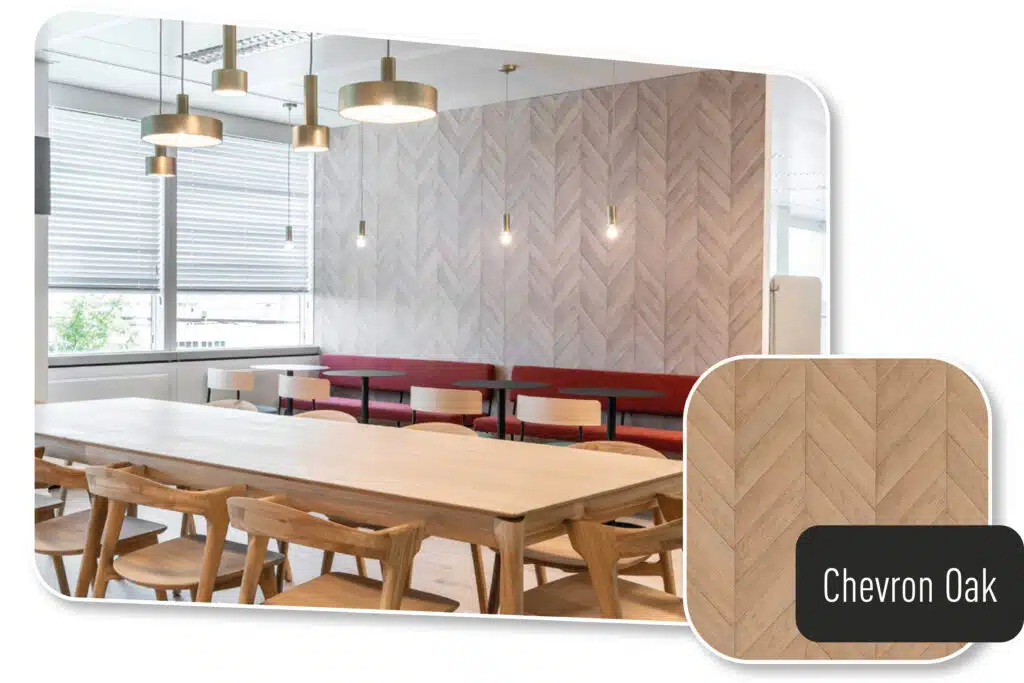 Ein stilvoll gestalteter Ess- oder Aufenthaltsbereich mit einer modernisierten Wandverkleidung in „Chevron Oak“-Optik. Die Holzstruktur der Möbelfolie verleiht dem Raum eine warme und einladende Atmosphäre. Die Kombination aus natürlichen Holztönen, eleganten Pendelleuchten und einer harmonischen Sitzgestaltung sorgt für ein zeitloses und ästhetisches Design.